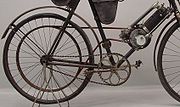 Riemaandrijving op een Clémen]-motorfiets uit 1908. De ketting diende voor het "aanfietsen"